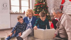 Grandparents sitting with their two young grandsons, reading a book together in a cozy holiday setting with a Christmas tree and festive decorations in the background. Griffith Law Office logo is visible in the corner.